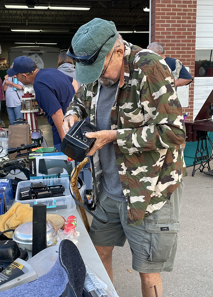 Kenneth Laws inspects a film camera at the Casar townwide yard sale. 