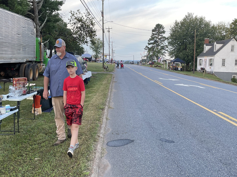 Father and son, Zane and Rudsell White, stroll down main street  in search of some items during the Casar townwide yard sale.