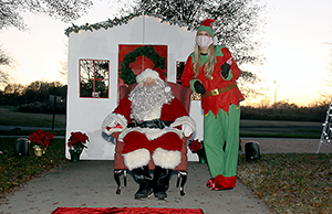 Santa and Elf Lydia Eaker await anxious kids at the Shelby City Park Carrousel Christmas Drive -Thru 