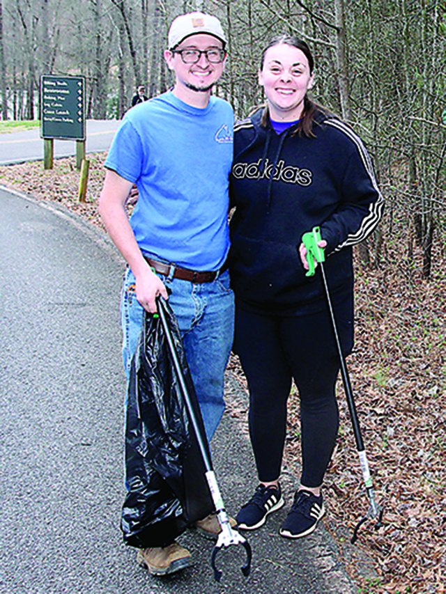 Husband and wife, Taylor and Aaron Alexander, clean up along the main road into Broad River Greenway 