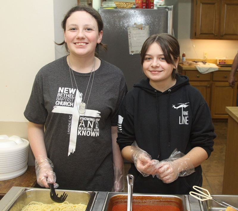 Jordyn Aberholdt and Adison Moore prepare spaghetti dinners at the New Bethel Baptist Church Valentine supper fundraiser.