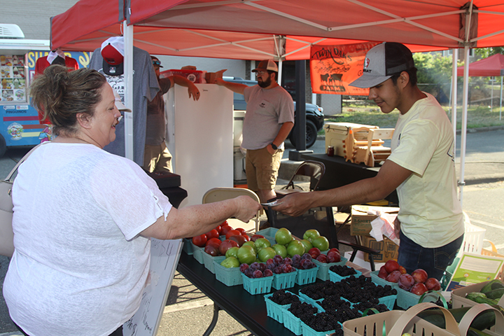 Crystal Oliver is pictured purchasing some fresh produce from Juan Cortez at the Kings Mountain Foothills Farmers' Market last weekend.